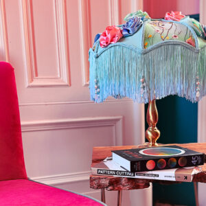 A highly decorative green floral lampshade on a brass base.