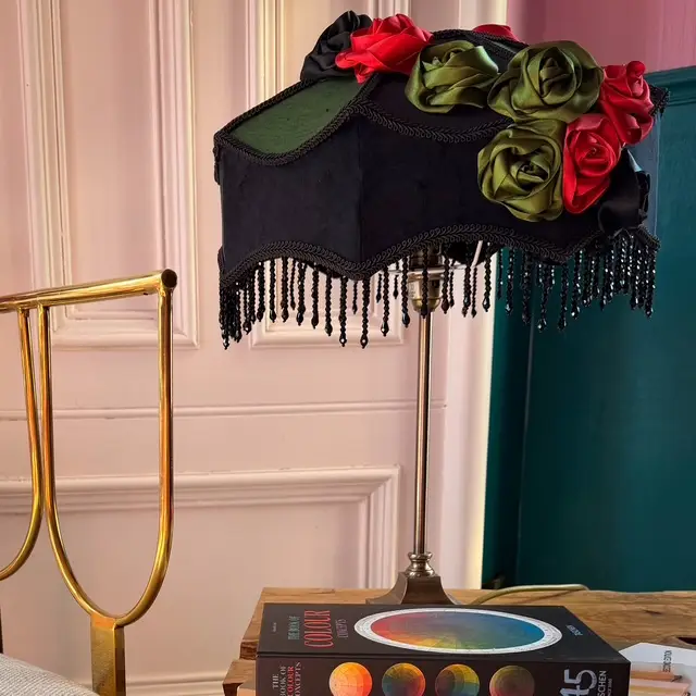 A black and green lampshade with floral embellishment in a sitting room